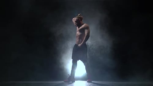 Pumped Up Guy Dances Sexy Dance. Black Smoke Background