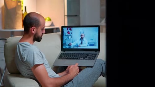 Man On Couch Has Video Call With Doctor