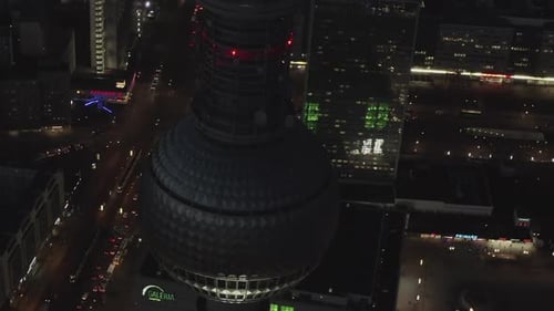 AERIAL: Close Up of Berlin Germany TV Tower Alexanderplatz at Night with City Lights Traffic