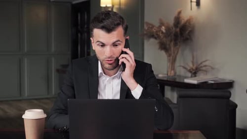 Closeup Focused Man Talking on Mobile Phone in Hotel Office