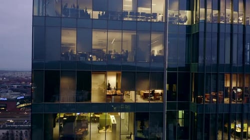 Skyscraper in the Late Evening with Offices and Workers