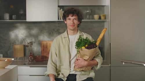 Portrait of Man Holding Grocery Bag on Modern Kitchen
