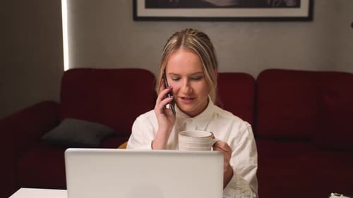 Pretty Young Businesswoman Professional Talking on Phone Using Laptop Sitting at Home Office Desk