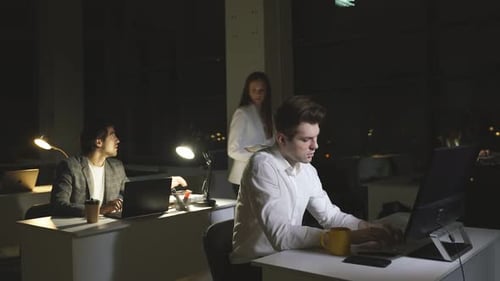 Une jeune femme d'affaires travaille avec des collègues au bureau la nuit