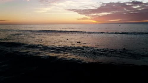 Surfers Catching Waves at Gorgeous Beach Sunrise