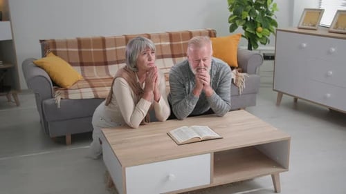 Senior Couple Praying Together at Home