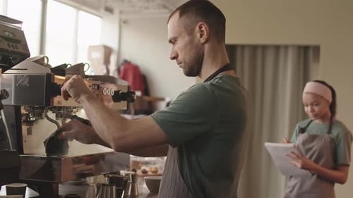 Männlicher Barista reinigt Kaffeemaschine im Restaurant