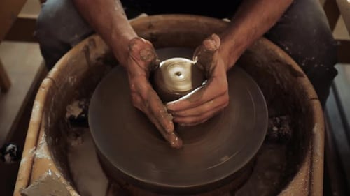 Potter Shaping Clay on a Spinning Pottery Wheel