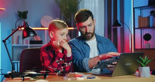 Father and Son Fixing Electronics at Home