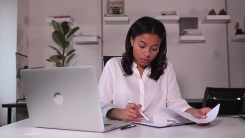 Businesswoman Talking in Front of Laptop and Looking at Resume at Table in Company Spbi