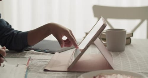 Young Adult Studying with Tablet at Table