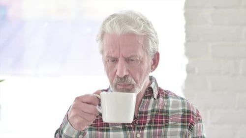 Senior Man with Toothache Drinks from Mug