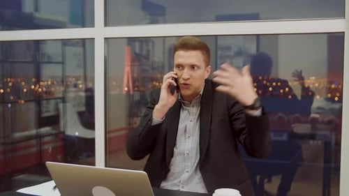 Angry Businessman Talking on Phone in Office