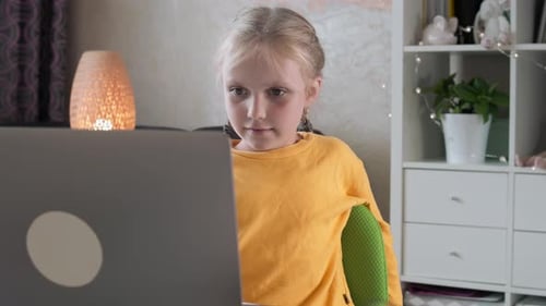 Girl Engaged with Laptop in Bright Home Setting