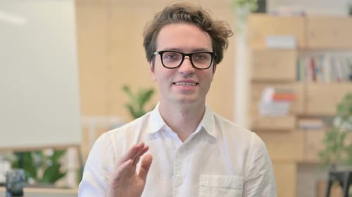 Young Man Gesturing and Speaking Indoors