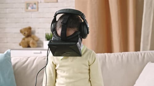 Girl with VR Headset and Headphones in Home
