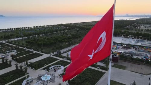 Turkish Flag Waving Over City Park at Sunrise