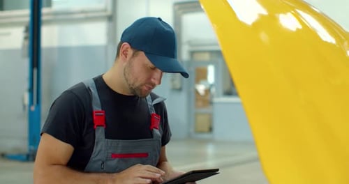 Car Service Manager Uses a Tablet Computer with an Augmented Reality Diagnostics Software.