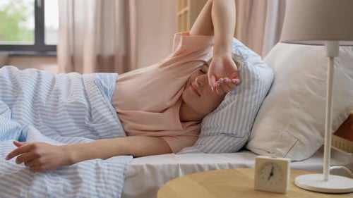 Woman Wakes Up, Stretches in Bed