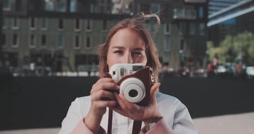 Woman Taking Photo with Vintage Camera in City