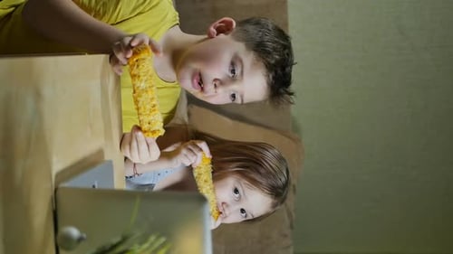Children Eating Corn Watching Laptop Together