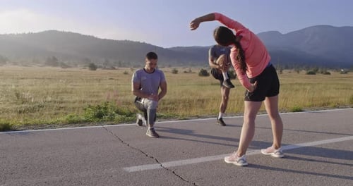 Multiethnic Group of Athletes Stretching Together on a Panoramic Road