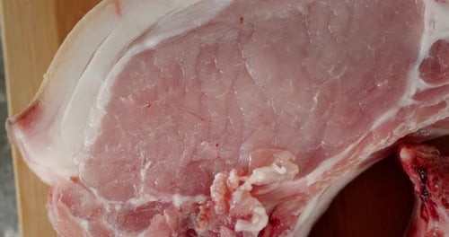 Raw Pork Chop on Wooden Surface