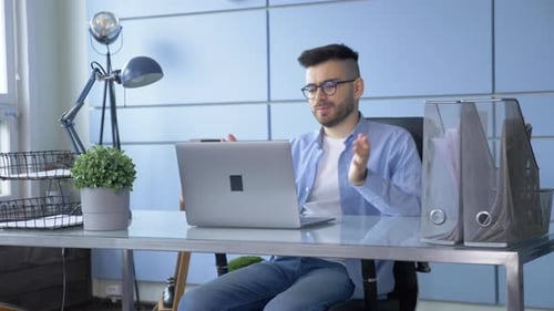 Man Attends Video Conference in a Modern Office