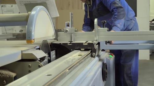 Man Using Industrial Saw in Woodworking Factory