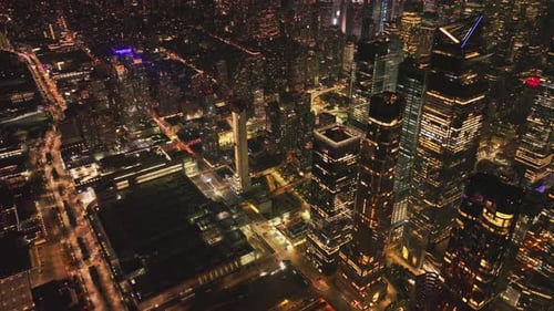 Cars Driving on Street Between High Rise Buildings in Night City