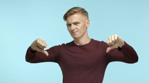 Young Adult Gives Thumbs Down Gesture with Both Hands