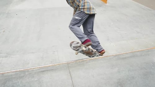 Skater Practicing in the Autumn Concrete Skate Park Making Tricks and Rides in Ramp