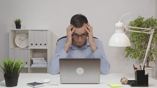 A Business Man Who Is a Company Employee Using a Laptop To Work in an Office Feel Tired From Work