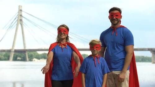 Family Dressed as Superheroes Poses Together Outdoors