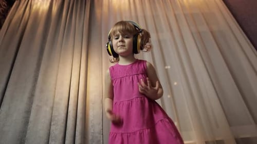 Cute Girl Dancing with Headphones Indoors