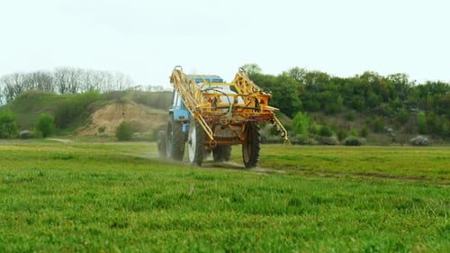 O trator concluiu o trabalho no campo e percorre a distância ao longo de uma estrada rural ao pôr do sol