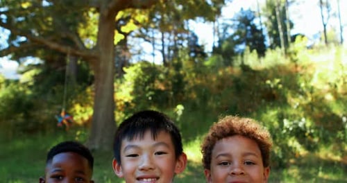 Portrait of happy kids sitting in park