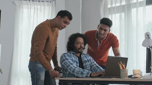 Un equipo de desarrolladores de software indios habla sobre el trabajo en la oficina