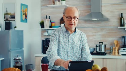 Adult Using Tablet in Modern Kitchen
