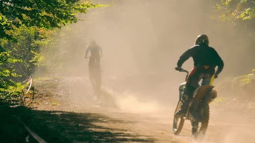 Motorcycles Riding Fast on Dusty Forest Track