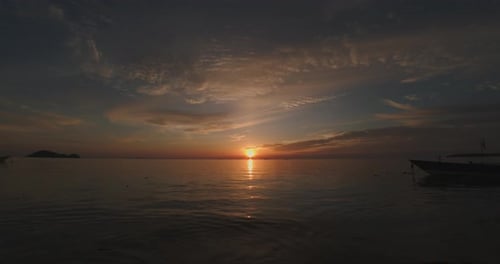 Sun goes down to the sea with light reflection on water