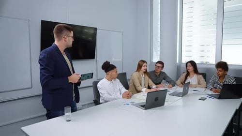 Businessman Giving Presentation to Colleagues in Office