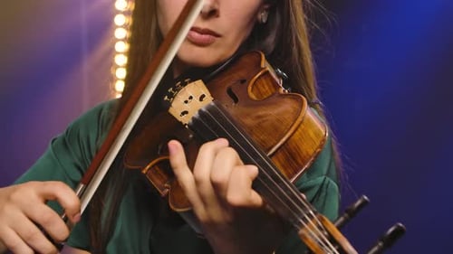 A Virtuoso Violin Performed By a Young Woman. Hands of a Female Violinist Close Up. Slow Motion.