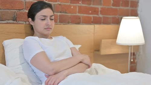 Woman resting in bed in white bedroom