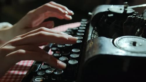 Hands Typing on Antique Typewriter Keyboard Close Up