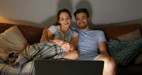 Couple watching movie on laptop at home 4k