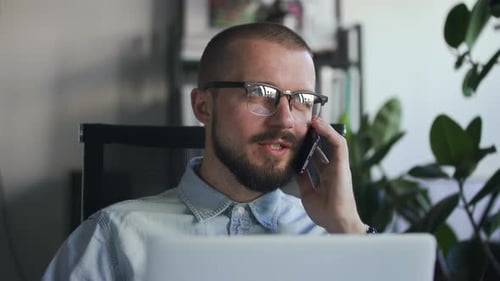 Man Talking on Phone in Home Office