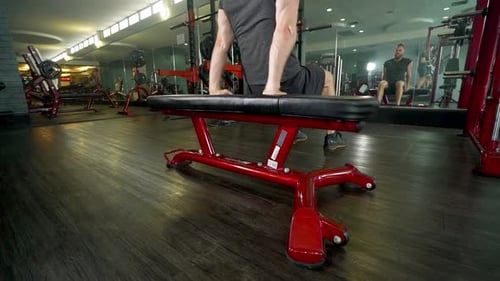 Man Exercising on a Weight Bench in Gym