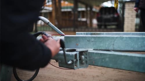 Man Connects Utility Trailer to Vehicle