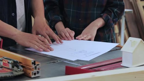 Close up of Man and Woman discussion construction for built-in furniture project in workshop